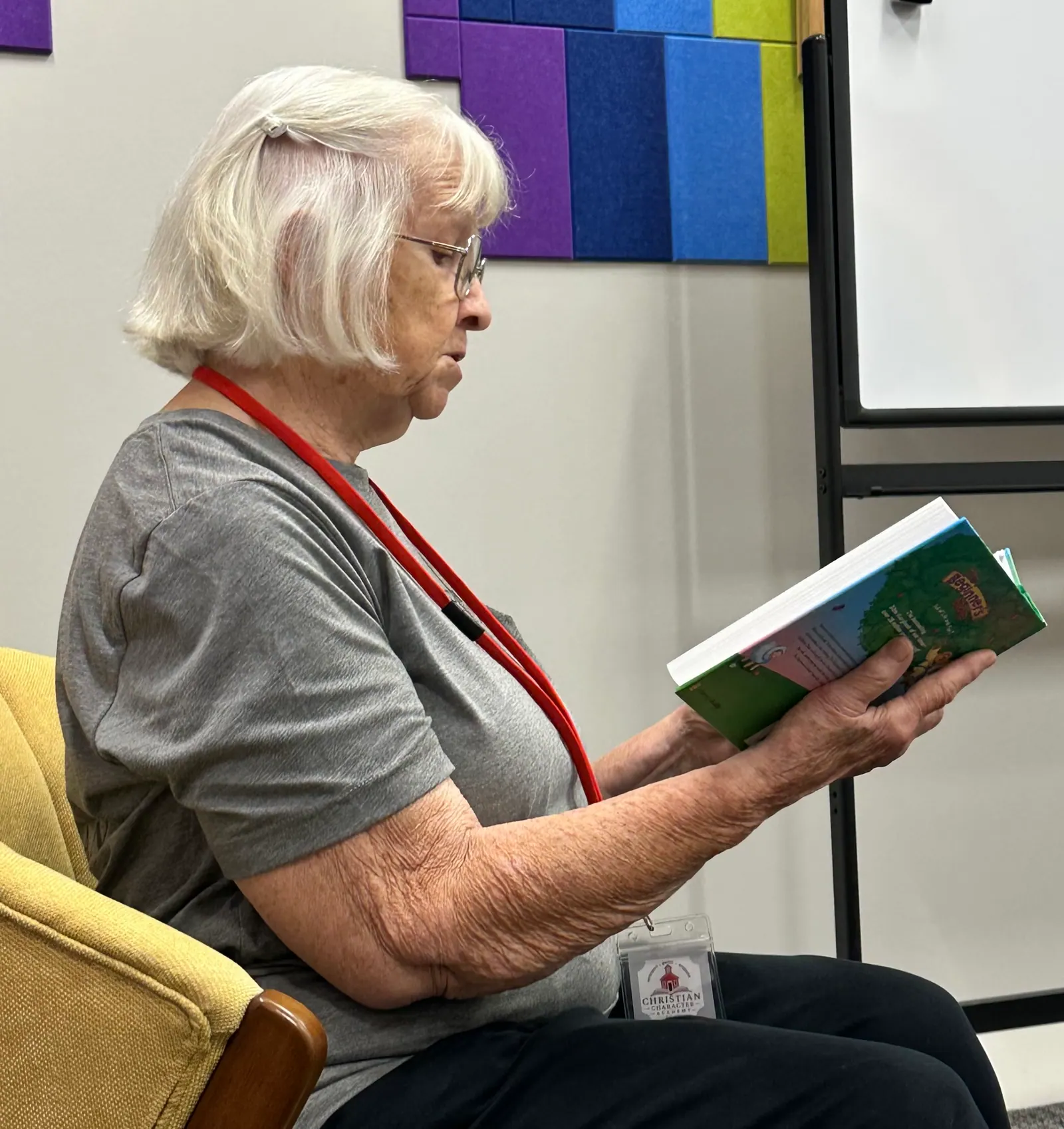 A Christian Character Academy volunteer reading a Bible storybook aloud during class